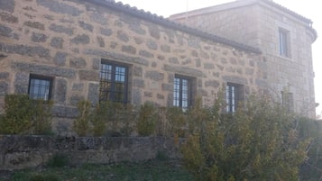 A stone building with multiple windows and a flat roof.