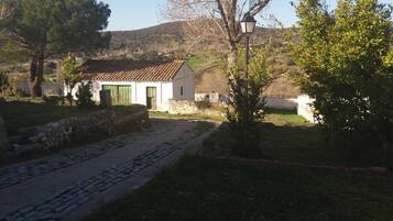 A rural setting with a white building, a cobblestone path, and a lamp post.