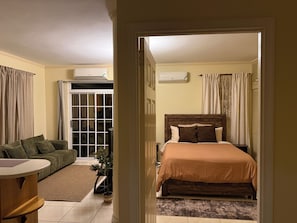 A hotel room with a bed, a sofa, a small table, and a potted plant. - Spacious and centrally located 1 bedroom apartment in the heart of Kingston (Kingston)