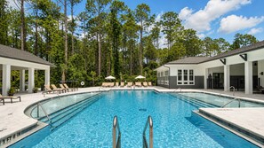 A swimming pool with a clear blue water, surrounded by lounge chairs and umbrellas, with trees in the background. - 4 min to Airport/King Bed/Pool/24hr gym/Lake view (Jacksonville)
