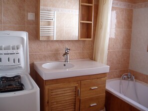 A bathroom with a sink, mirror, wooden cabinet, and a bathtub. - Chalet 'Les Lauzes 3 Bonneval-sur-Arc' (Bonneval-sur-Arc)