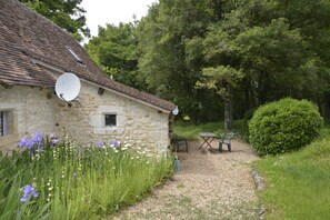 A stone house with a satellite dish, a gravel path, and a bench. - Country House 'Hameau des Rabauds - La Tourderie' with Pool, Private Garden & Wi-Fi (Saint-Pierre-de-Maillé)