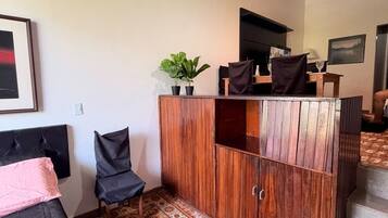 Une pièce comprenant un lit, une armoire en bois, une chaise et un tapis à motifs.