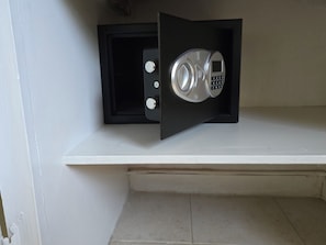 A safe with a keypad, installed in a black cabinet against a white wall. - Cassywins Short Term Rentals Apt #6 (Bridgetown)