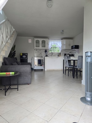 A compact living space with a kitchenette, a dining area, and a seating area with a sofa and a table. - Cassywins Short Term Rentals Apt #6 (Bridgetown)