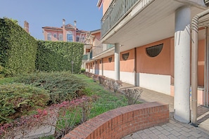A building with a brick pathway, a hedge, and a clear sky. - Apartment 'Smart Hub M3 Metro 10 Min.Duomo' with shared garden, Wi-Fi and air conditioning (Milano)
