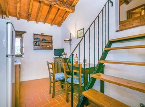 A staircase with wooden steps and a metal railing, leading to a room with a tiled floor and a wooden ceiling. - ​An Oasis of Peace & Flavor: Welcome to La Colombaia (Lucolena In Chianti)