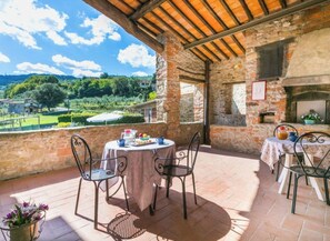 An outdoor patio with stone walls, a brick oven, and a table set for dining. - ​An Oasis of Peace & Flavor: Welcome to La Colombaia (Lucolena In Chianti)