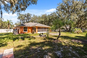 A residential property with a house, a patio, and a lawn. - Charming Kissimmee Retreat Near Orlando (Kissimmee)