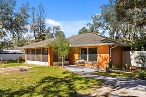 A residential house with a patio, a small garden, and a clear sky. - Charming Kissimmee Retreat Near Orlando (Kissimmee)