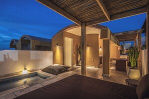 Ein überdachter Außenbereich mit Pool, Esstisch und Stuhl.