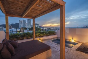 Un balcon agrémenté d’une pergola en bois, une petite piscine et un espace détente avec des coussins.
