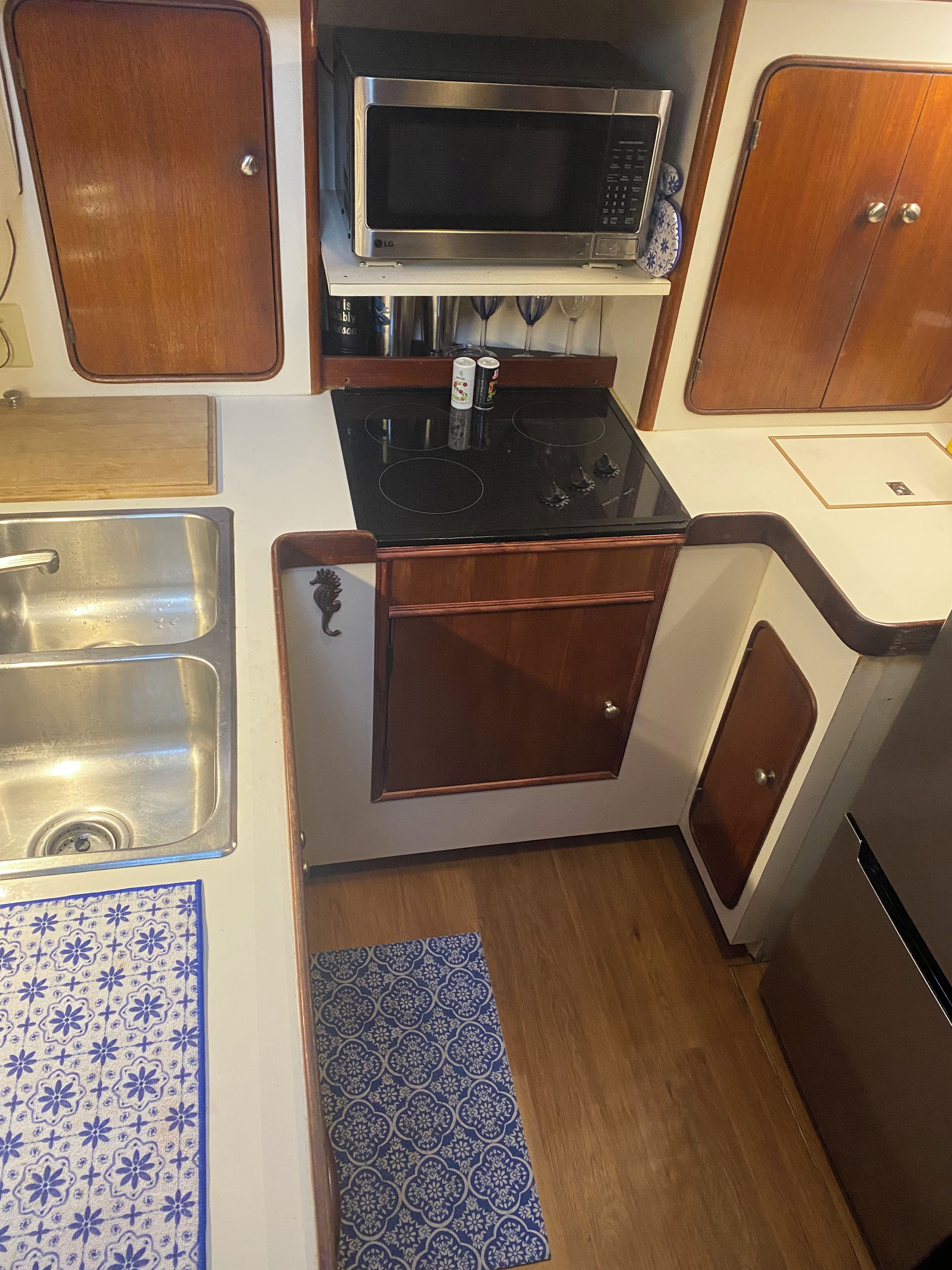 Une petite cuisine équipée d’un four à micro-ondes, d’une cuisinière, d’un évier et de placards.