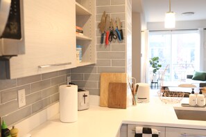 A modern kitchen with a white countertop, a toaster, a cutting board, and a knife rack. - Modern 2BR/2.5BA Townhouse w/ dedicated Office, PET FRIENDLY near Sloans Lake (Lakewood)