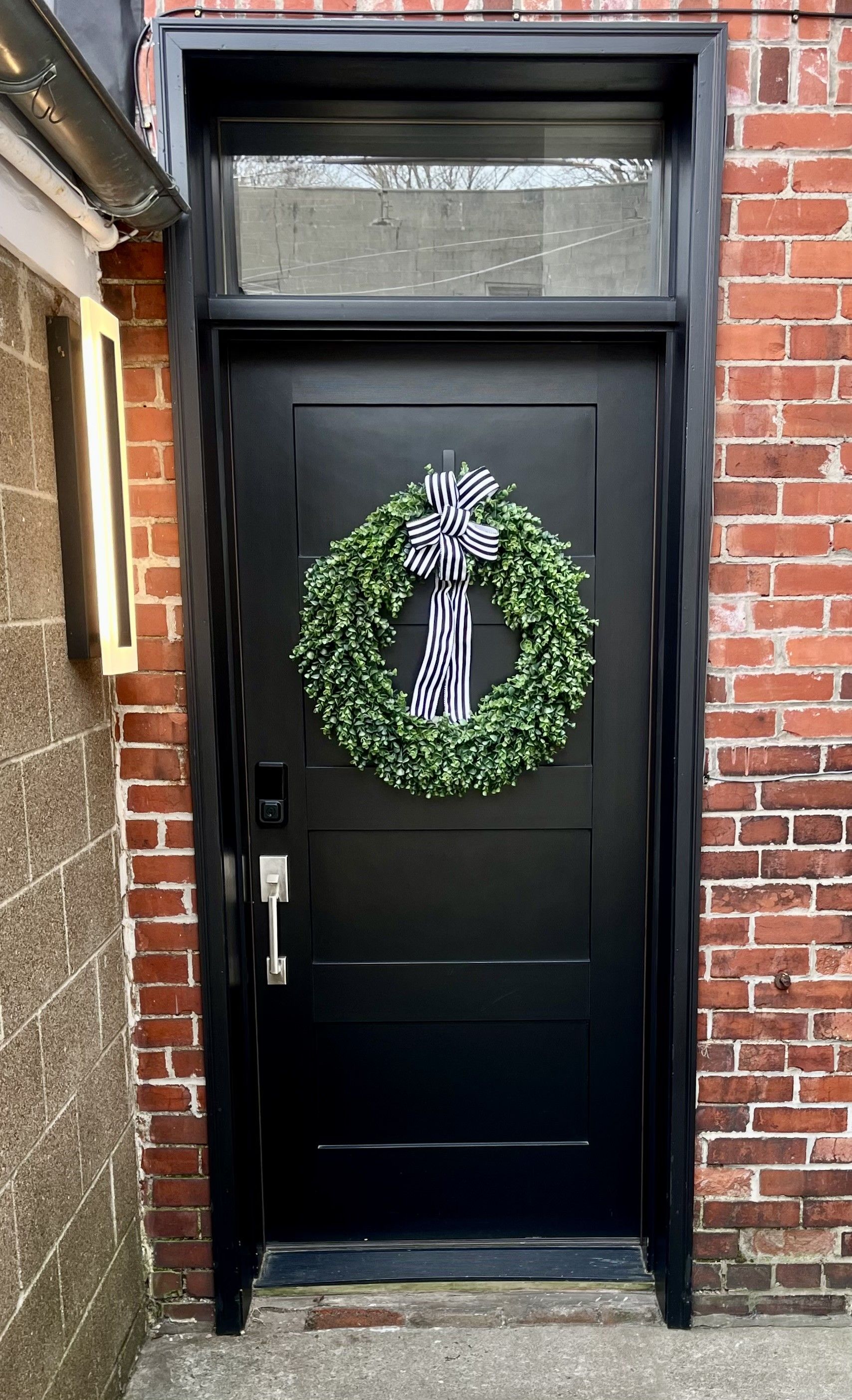 A black door with a wreath and a keyhole.