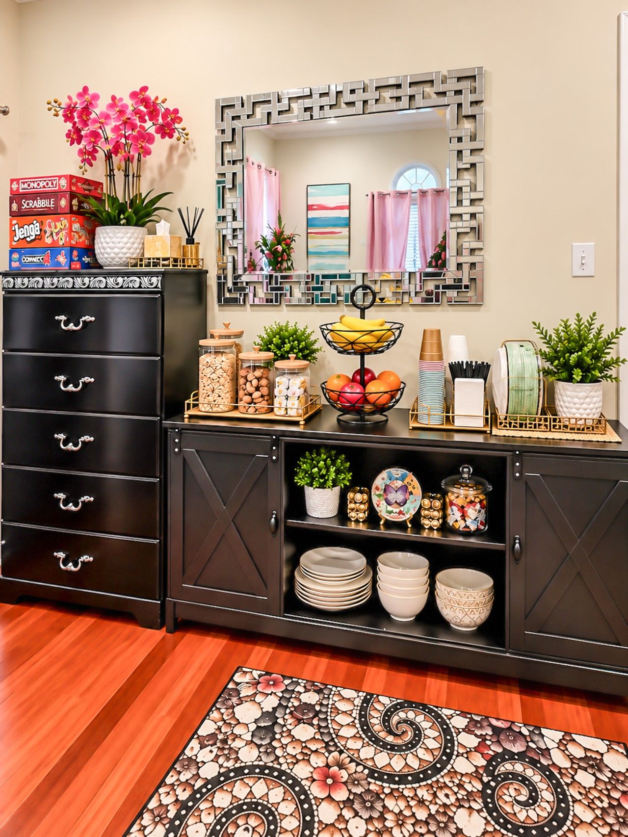 A modern living room with a black cabinet, a decorative mirror, and a floral rug.