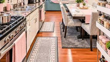 A modern kitchen with a central island, a dining area with a bench, and a living space with a TV.