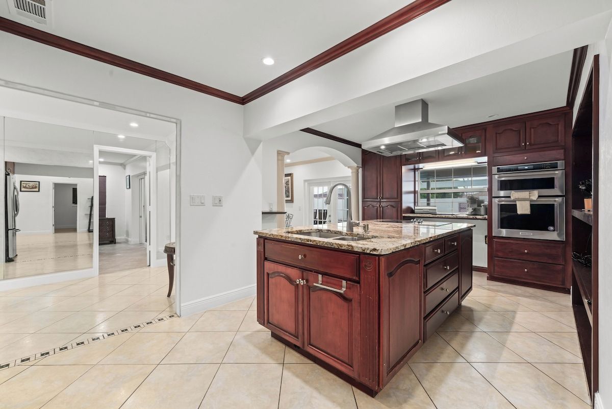 A spacious kitchen with a large island, built-in oven, and a modern design.