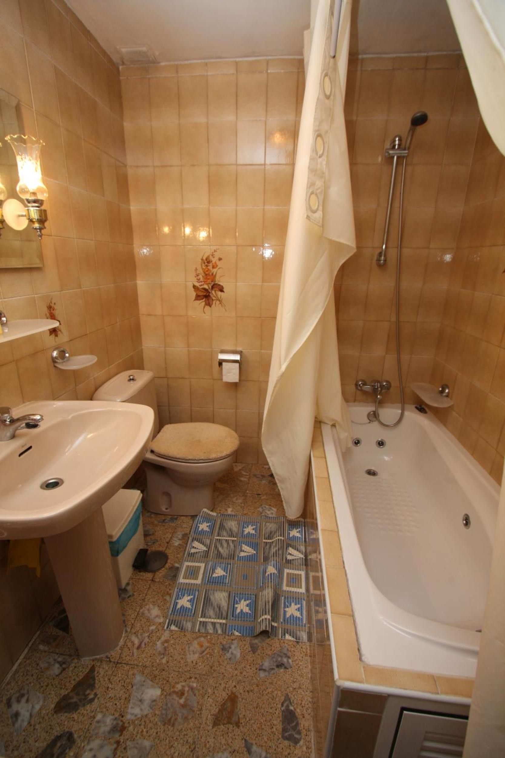Een badkamer met toilet, wastafel, bad en douche.