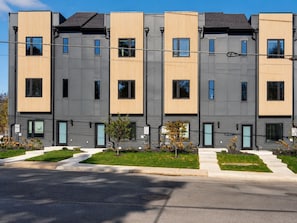A modern multi-story residential building with a symmetrical facade, evenly spaced windows, and a flat roof. - Rooftop Lounge, Walk to Restaurants, 3 miles to Downtown (Nashville)