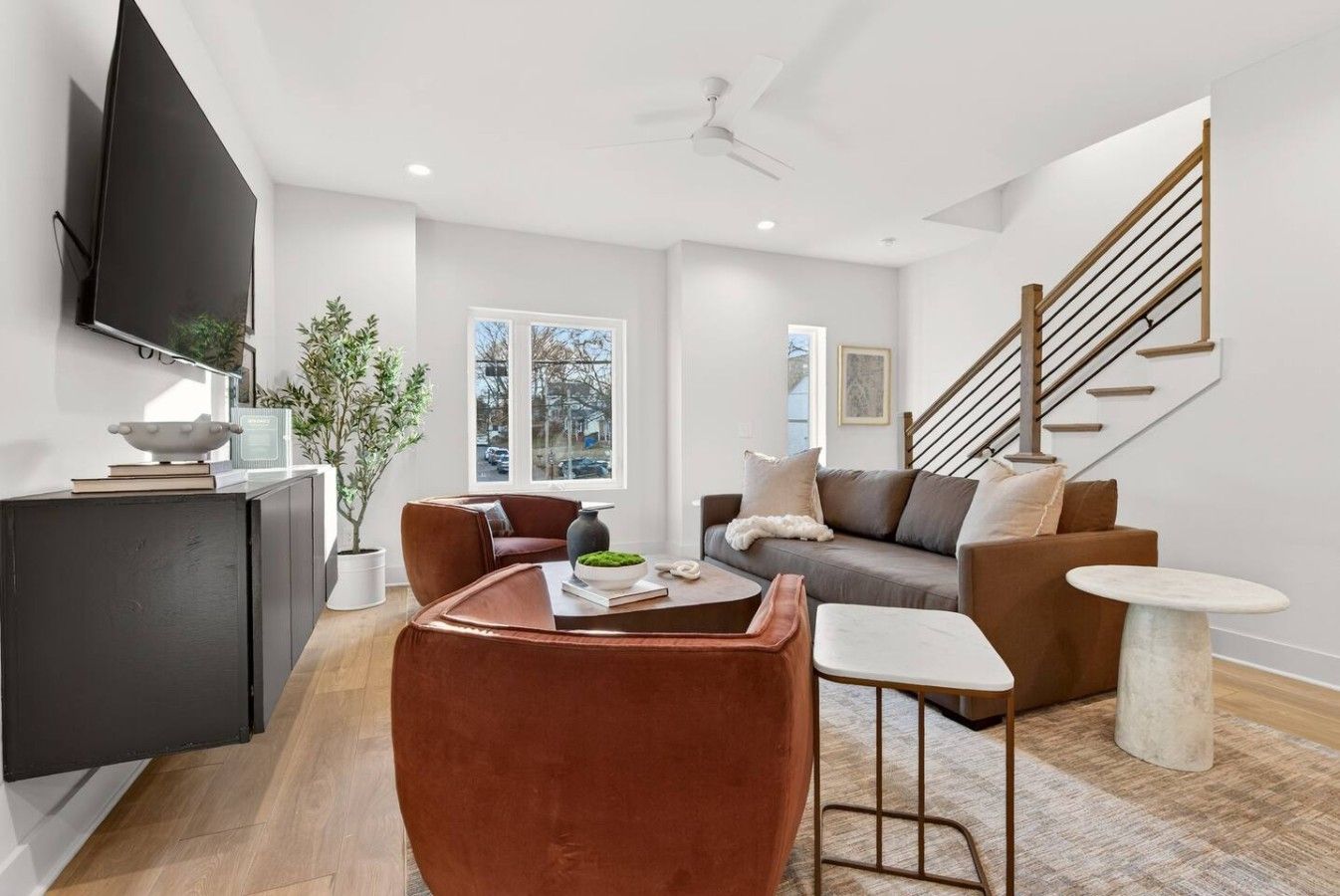 A modern living room with a sofa, coffee table, and a TV mounted on the wall.