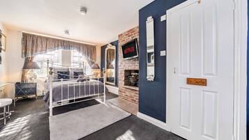 A bedroom with a bed, a television, a fireplace, and a door labeled 'En Suite.'