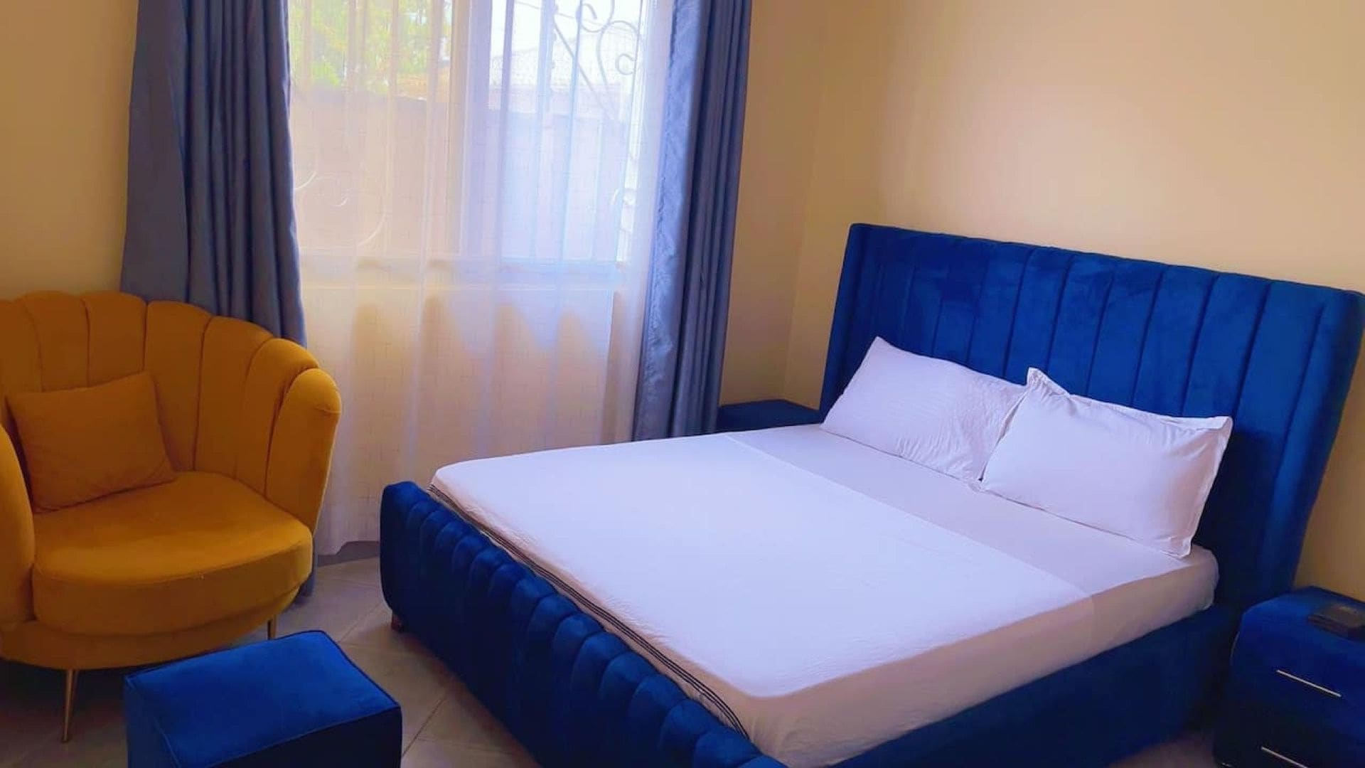 A hotel room with a bed, a chair, and a nightstand.