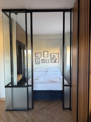 Quarto com cama, guarda-roupa e parede decorada com quadros.
