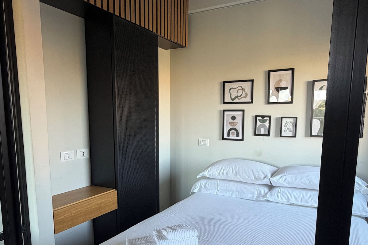 Ein Hotelzimmer mit einem Bett, einer Holzablage und einer Wand mit gerahmten Bildern.
