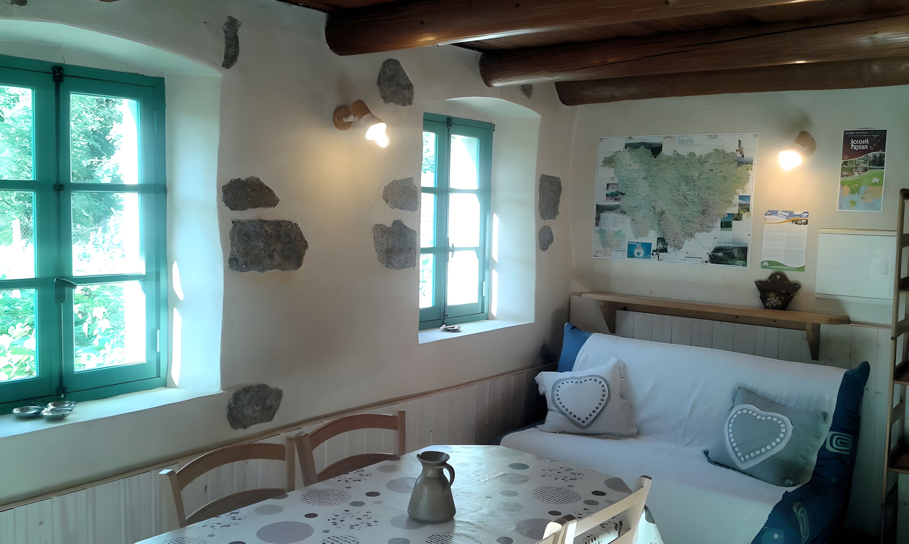 Ein Zimmer mit Tisch, Stühlen, einer Bank und einer Karte an der Wand.