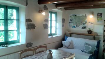 Ein Zimmer mit Tisch, Stühlen, einer Bank und einer Karte an der Wand.