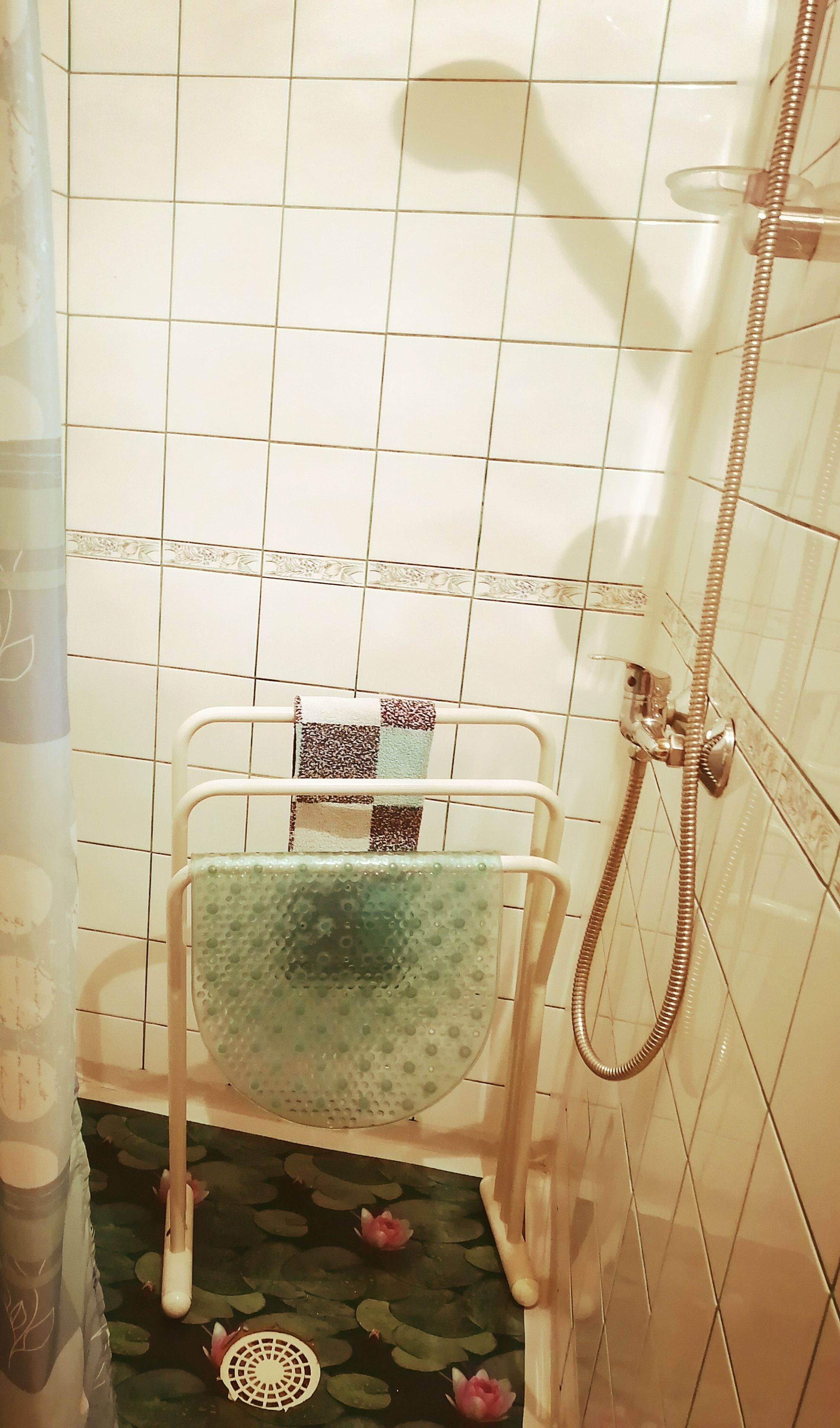 Une salle de bain avec une douche, des toilettes avec une serviette, et un rideau de douche décoratif.