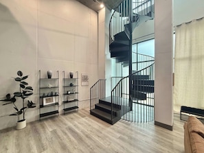Ein modernes Interieur mit einer Wendeltreppe, Holzböden und minimalistischer Einrichtung.