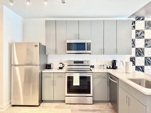 Eine moderne Küche mit Edelstahlgeräten, einer Mikrowelle und einem eingebauten Backofen.