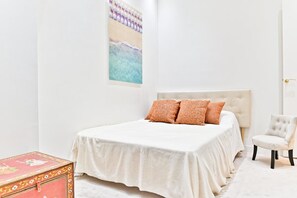 A bedroom with a bed, a chair, and a decorative box. - Parisian Luxury with Eiffel Tower Views & Designer Interiors (Paris)