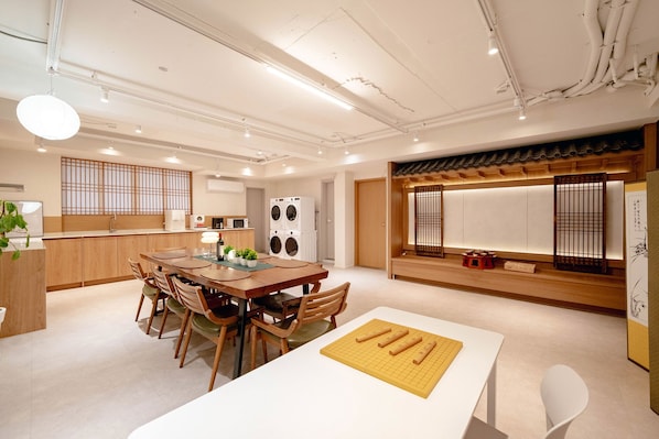 Cocina moderna con zona de comedor, que incluye armarios de madera, una isla central y una puerta corredera tradicional japonesa.