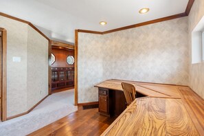 Habitació amb una taula de dinar de fusta, un armari de paret i un mur amb un disseny decoratiu.