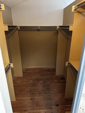 Ein schmaler Durchgangsschrank mit Holzboden und beigen Wänden.