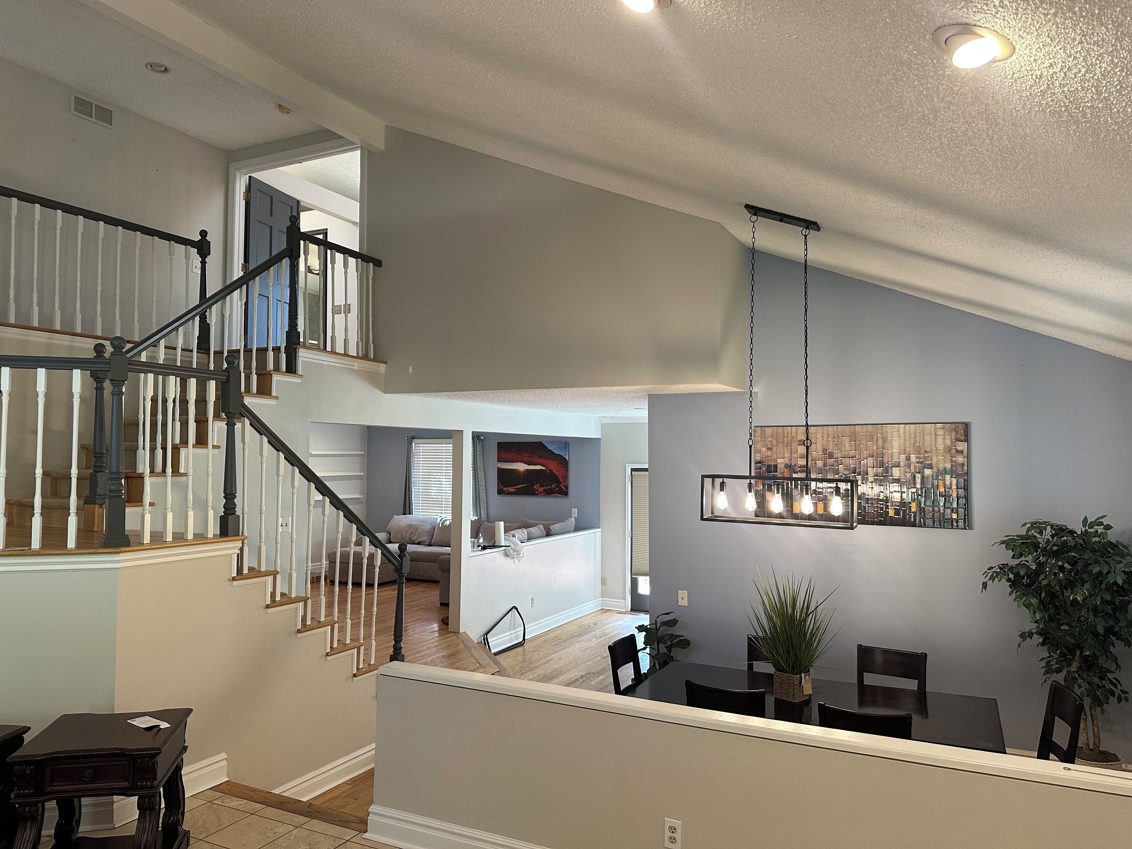 A multi-level home interior with a staircase, dining area, and living space.