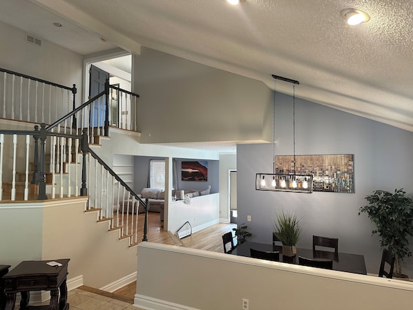 Interior de una casa con varios niveles, que incluye una escalera, comedor y sala de estar.