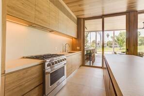 Eine moderne Küche mit Gasherd, Backofen und Holzschränken.