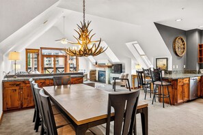 A spacious kitchen with a high ceiling, a central island, and a chandelier. - Mountain Views, Steps to Lift (Breckenridge)