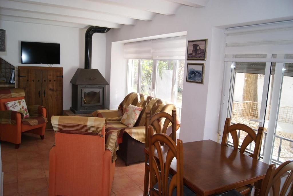 A living room with a sofa, chairs, a table, a fireplace, and a television.