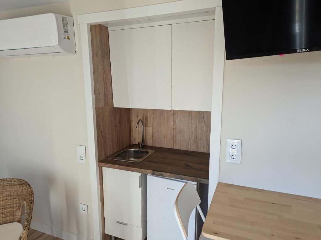 A compact kitchenette with a built-in sink, a small refrigerator, and a microwave.
