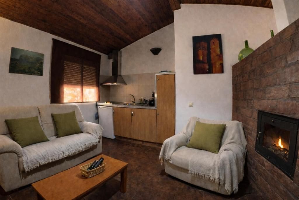 A cozy living room with a fireplace, a sofa, a chair, and a coffee table.