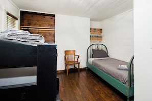 Una stanza piccola e funzionale con un letto a castello, una sedia e una libreria.
