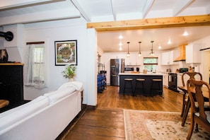 Una cucina moderna con isola centrale, sgabelli da bar e soffitto in legno.