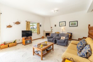 A living room with a television, sofa, and coffee table. - VILAMOURA GARDEN VILLA WITH POOL by HOMING (Vilamoura)
