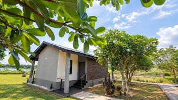A modern house with a flat roof, a small porch, and a staircase leading to the entrance.