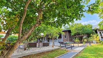 A park with a small building, a wooden pergola, and a pathway.